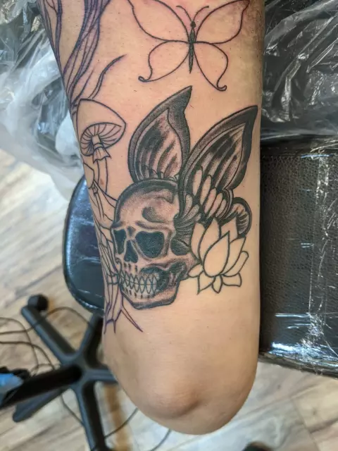 Choose the right tattoo in Houston - a skull and butterfly on the thigh.