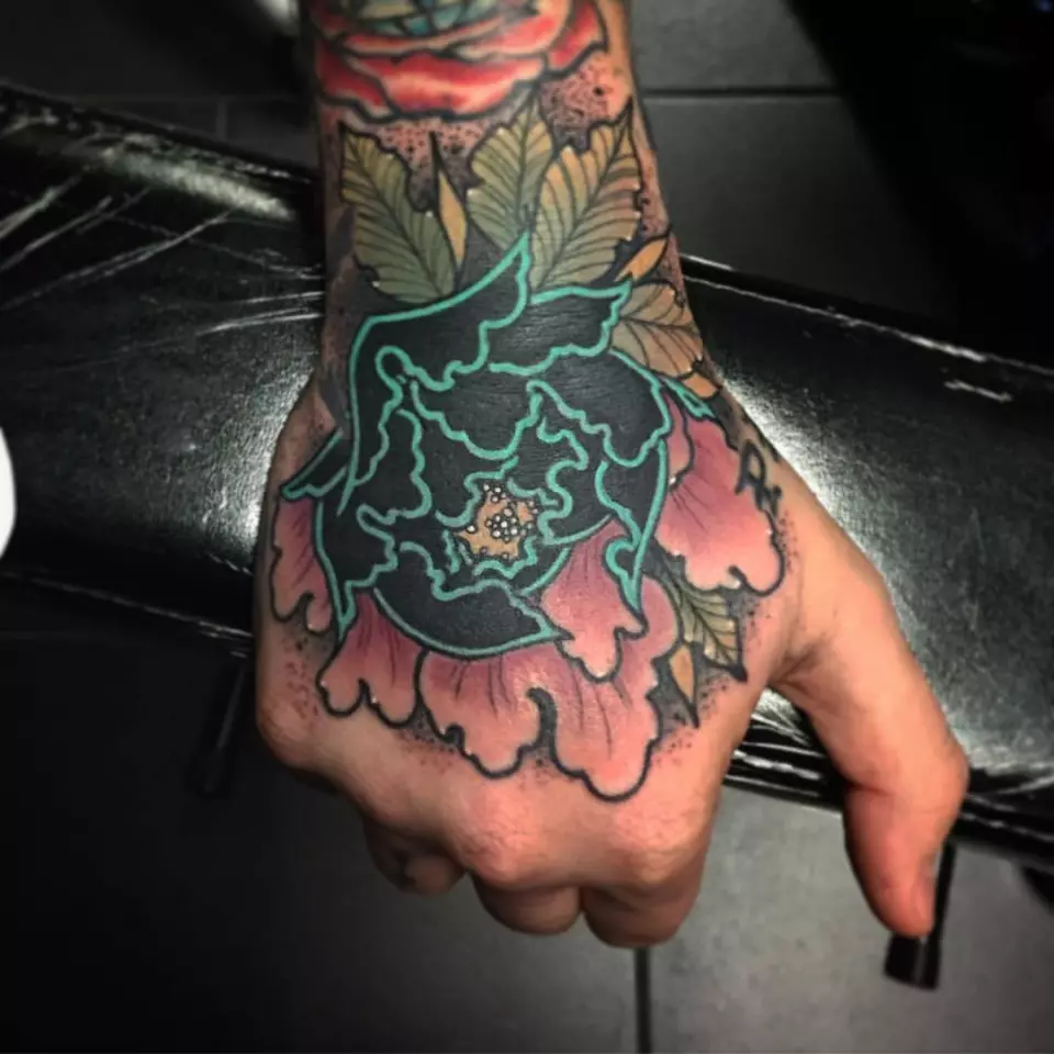 A stunning flower tattoo adorns a hand.