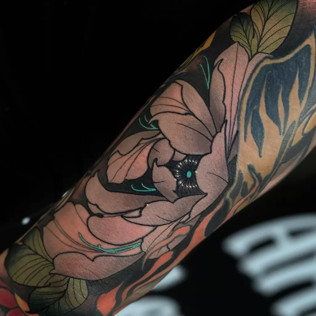 A traditional Japanese flower tattoo gracefully adorns a man's arm in Katy.