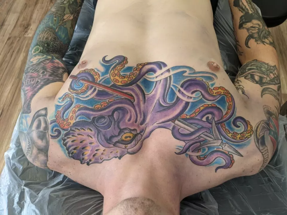 A man choosing an opal lotus tattoo on his back.