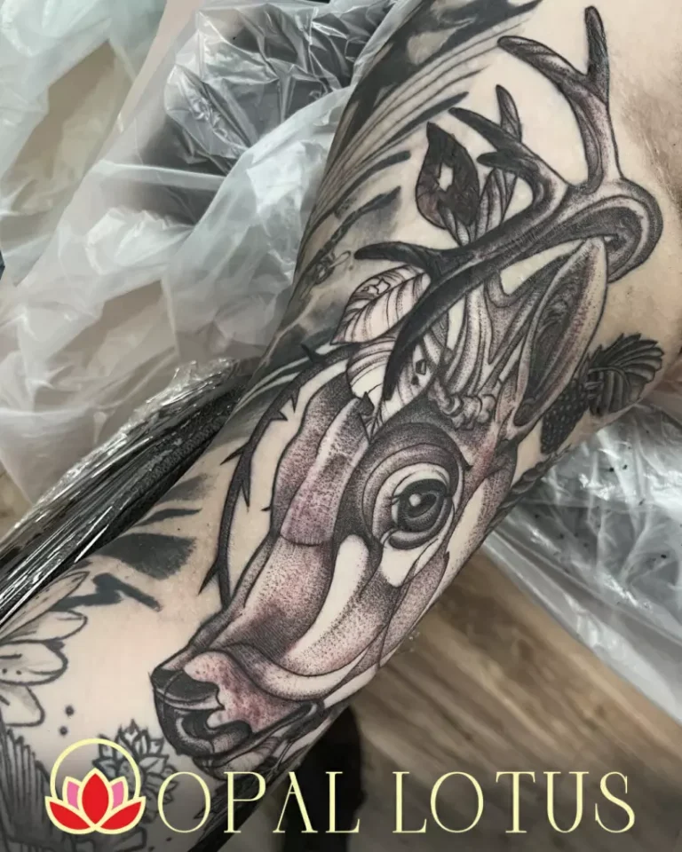 A black and grey tattoo of a deer with antlers, designed by Janice.