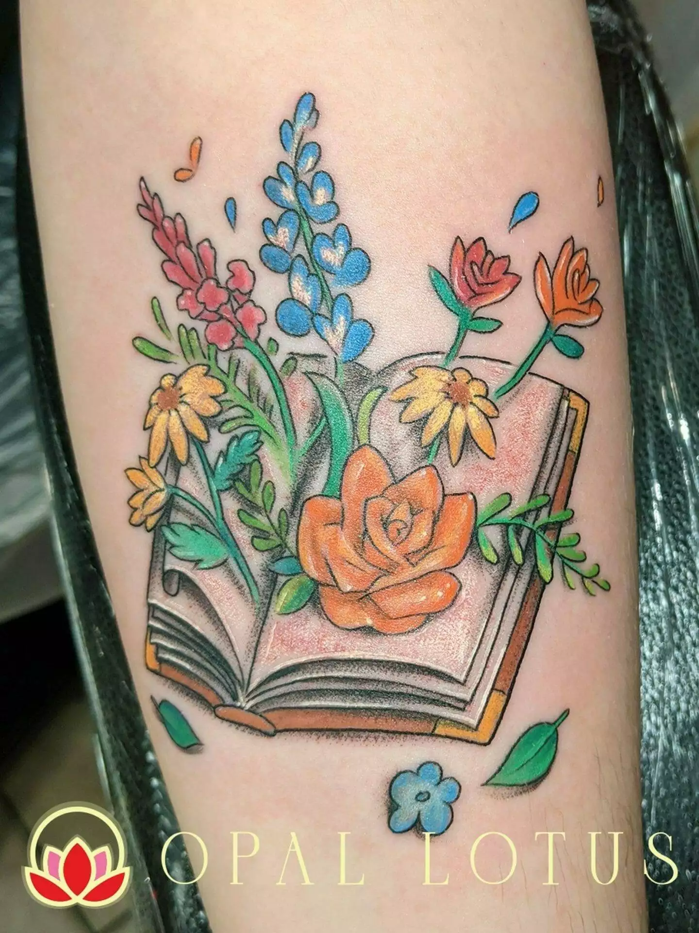 A floral tattoo featuring a book.