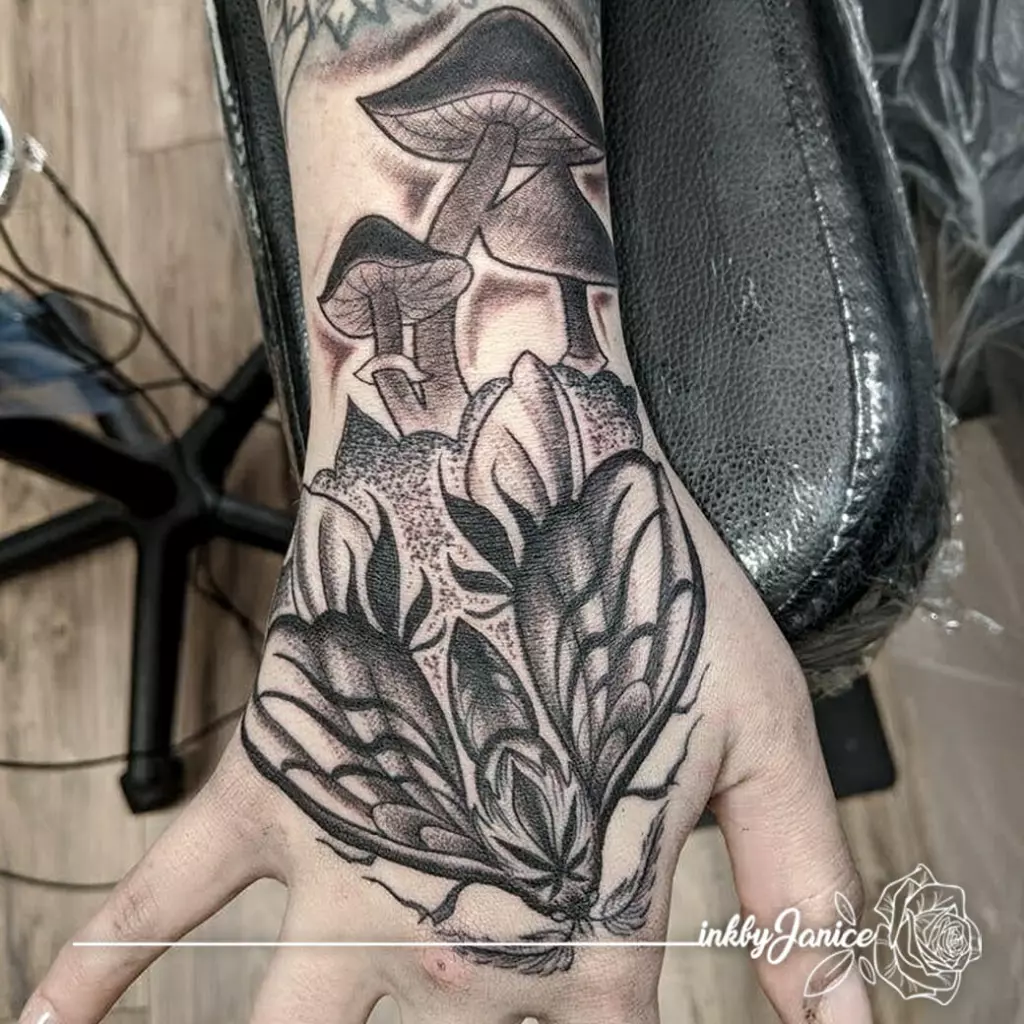 Janice's black and grey tattoo of a flower and mushrooms adorns her hand.