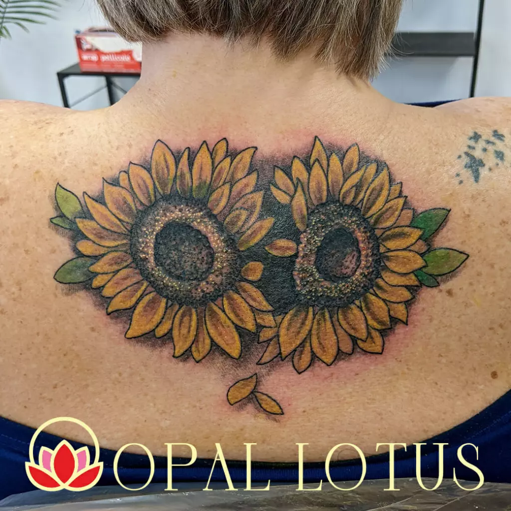 A woman with a floral sunflower tattoo on her back.